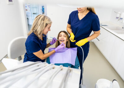 Female dentist with assistant working in dental clinic examining